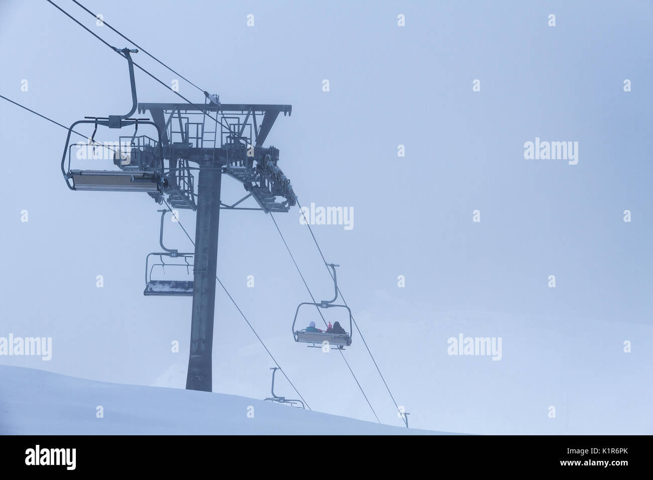 Ski lift chair on slope of hill covered by snow in mountains area by a ...