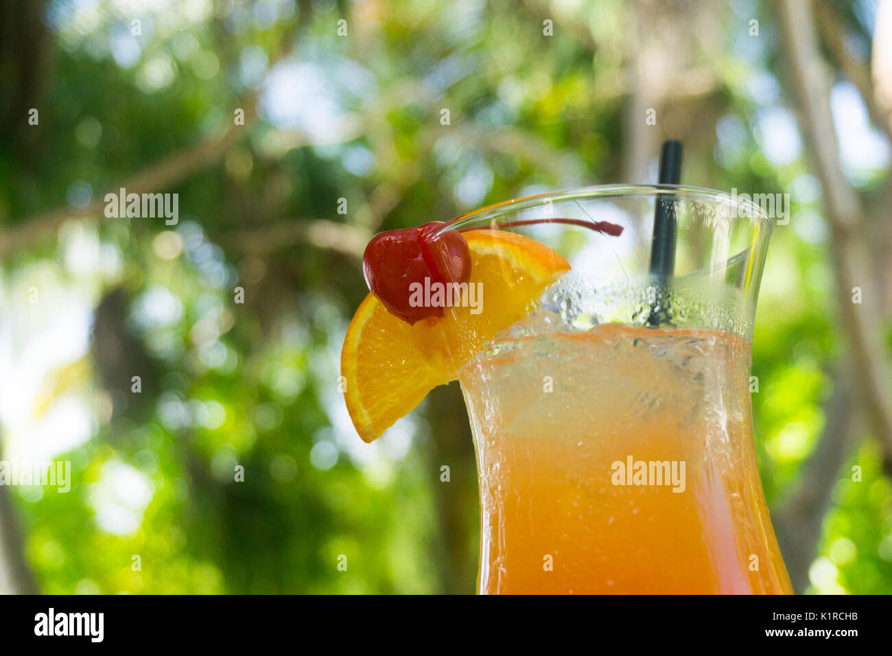 Tropical cocktail with orange and cherry garnish Stock Photo - Alamy