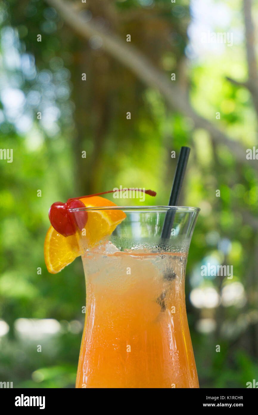 Tropical cocktail with orange and cherry garnish Stock Photo - Alamy