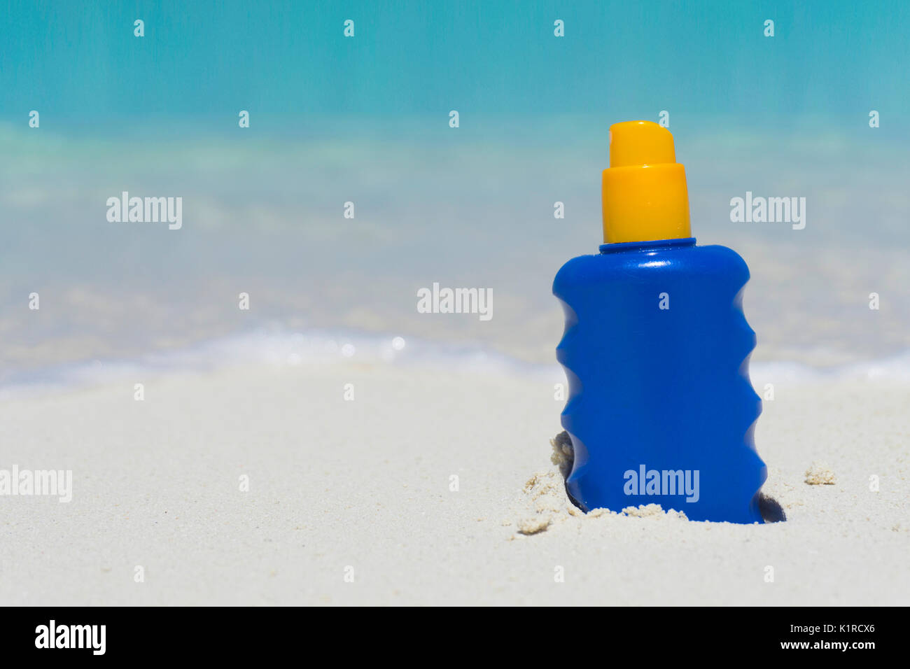 Bottle of sun lotion suncream protection on a tropical beach Stock Photo