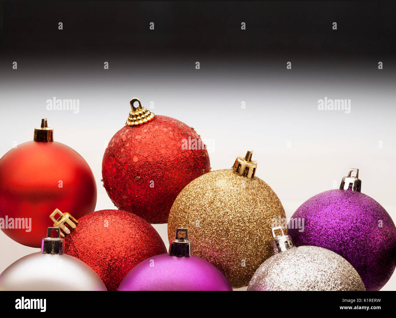 Colorful christmas balls against a gray gradient background. Stock Photo