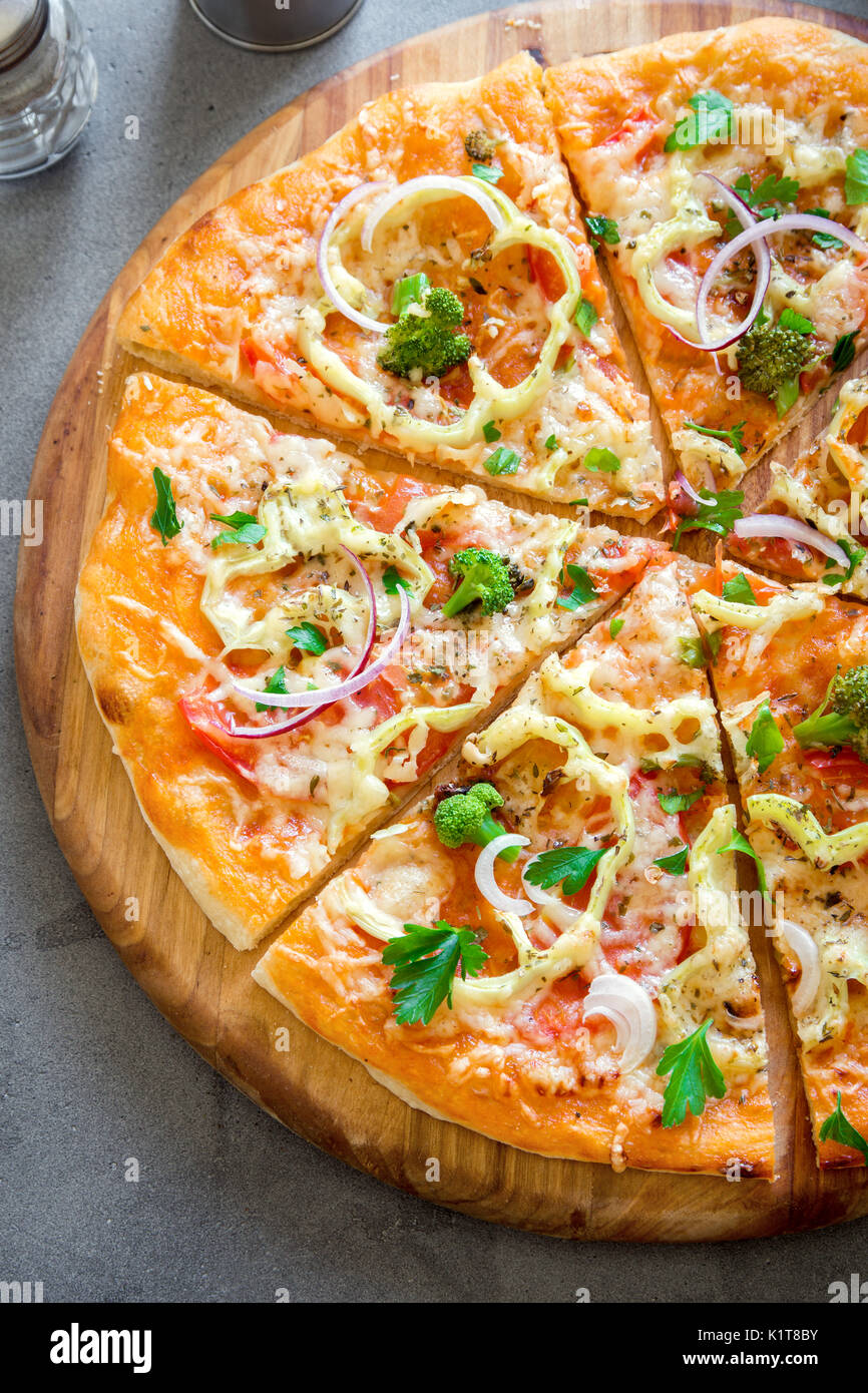 Vegetarian Pizza on rustic concrete background. Italian Pizza with Vegetables and Cheese close up. Stock Photo