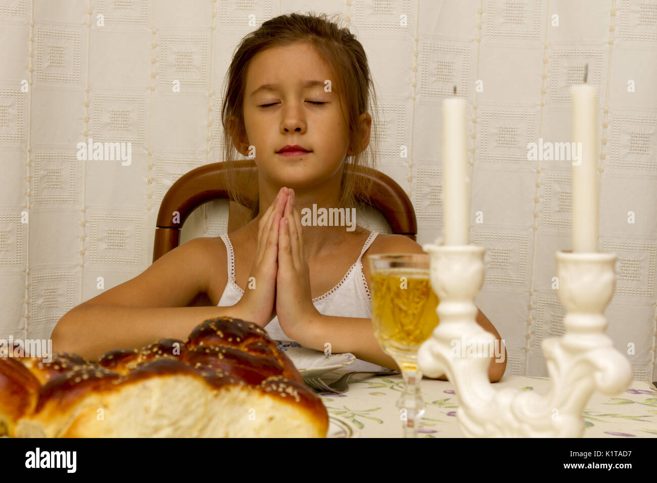 Jewish girl says the blessing upon lighting the sabbath candles before