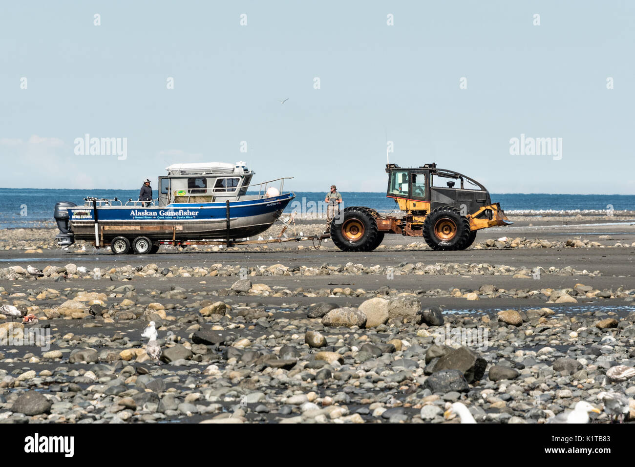 Fishing boats are towed by a tractor tug that will carry them back to