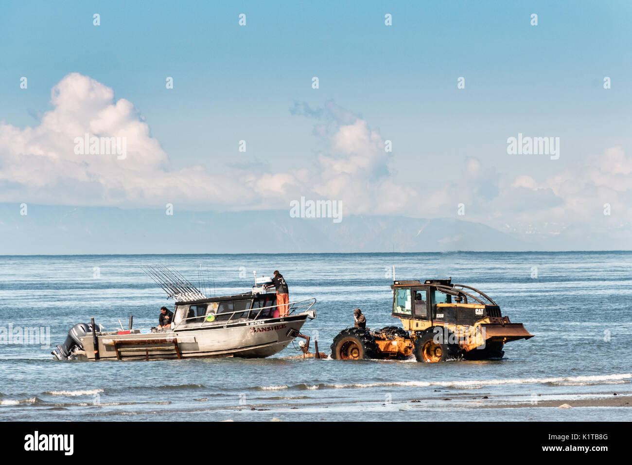 Fishing boats are towed by a tractor tug that will carry them back to