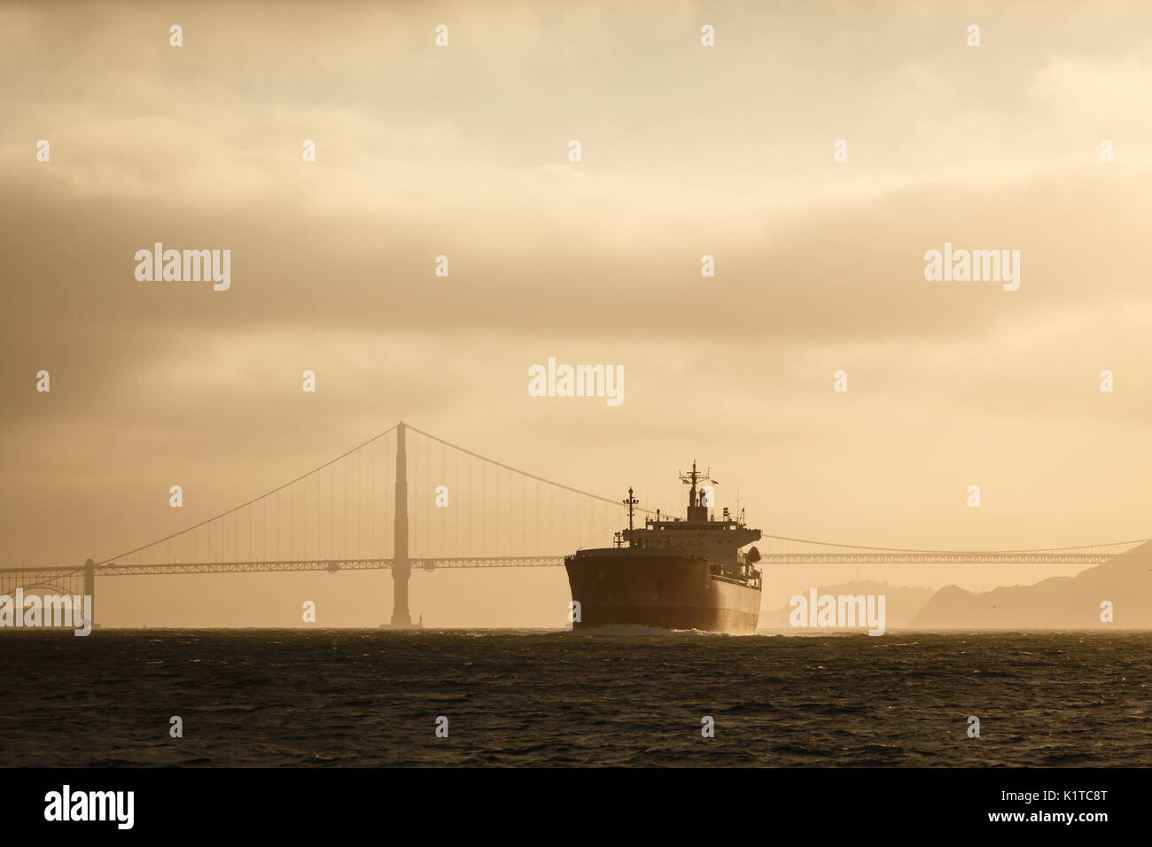 Giant tanker ship and golden gate bridge at sunset Stock Photo
