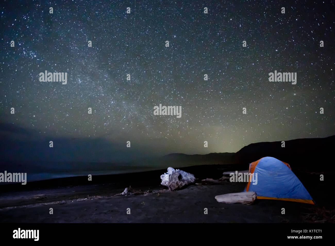 Tent camping under a myiad of bright stars on the beach Stock Photo