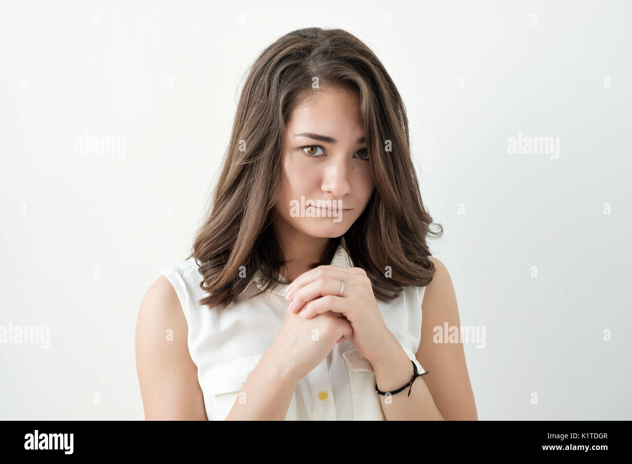Confused young female posing isolated at white wall. Stock Photo