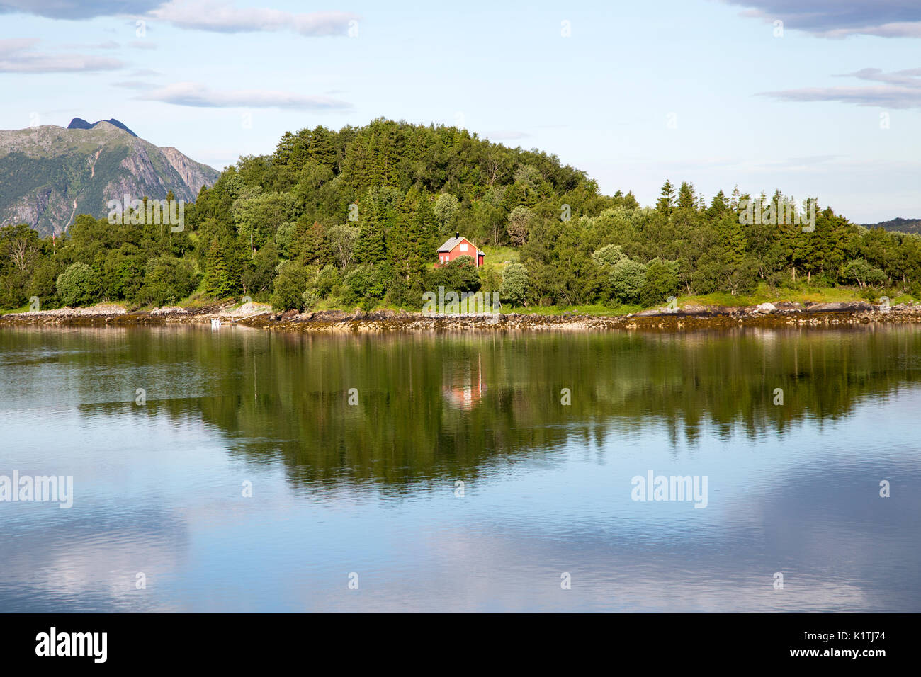 Isolated coastal house on small wooded island near Ornes, Nordland, Norway Stock Photo