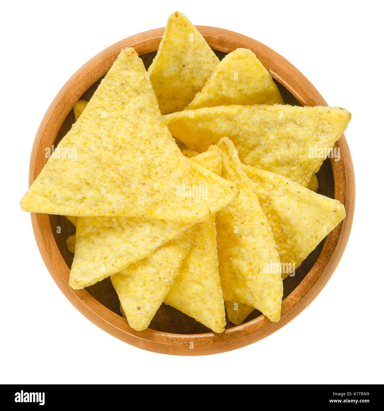 Tortilla chips in wooden bowl. Snack food made from corn tortillas or corn masa, cut into triangle shaped wedges, fried in oil and salted. Stock Photo
