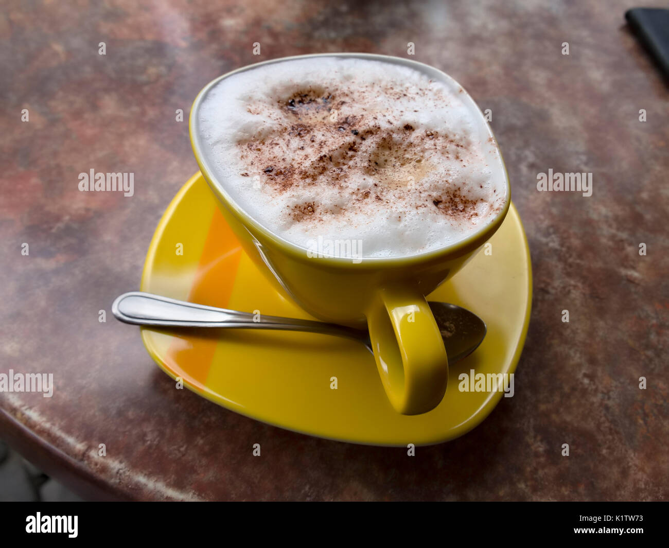 Cappuccino in a yellow cup Stock Photo