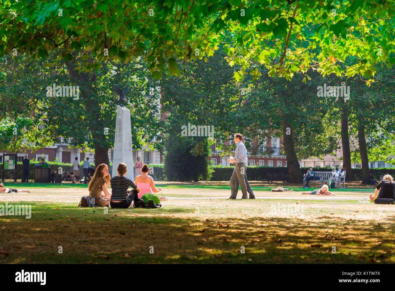 London square summer, view on a summer afternoon of young people relaxing in Grosvenor Square, London, England, UK. Stock Photo