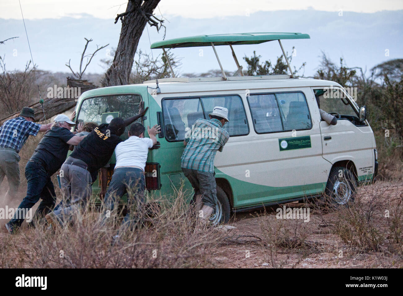Tourists helping to push out a Safari rig that had gotten stuck in the Samburu National Reserve, Kenya, Africa. Stock Photo