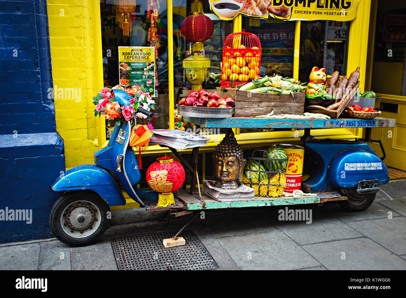 blue-motorbike-display-with-fruits-vegetables-lampoons-buddha-head