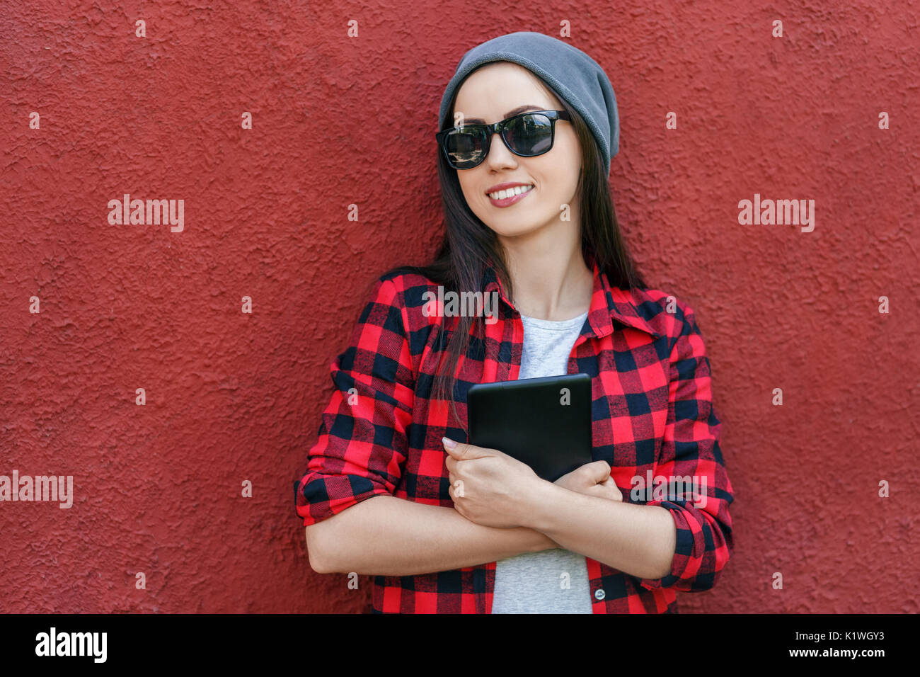 Portrait of a cheerful young woman holding tablet computer. Smiling girl with digital tablet outdoors, copy space, social networking concept Stock Photo
