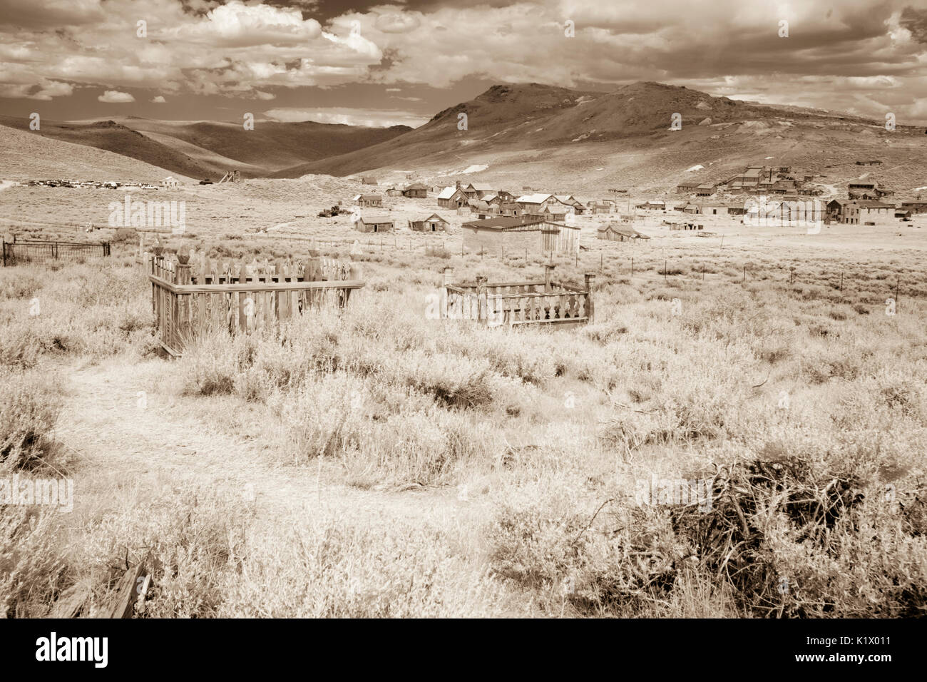 Ghost town from cemetery Bodie Historic State Park wooden buildings in sepia. Stock Photo