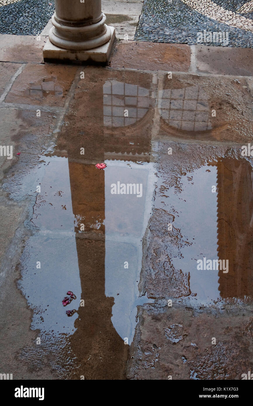 Reflection of a column in a puddle, Palace of the Dean Ortega, National Parador of òbeda, Jaen province, is one of the paradores oldest in Spain Stock Photo