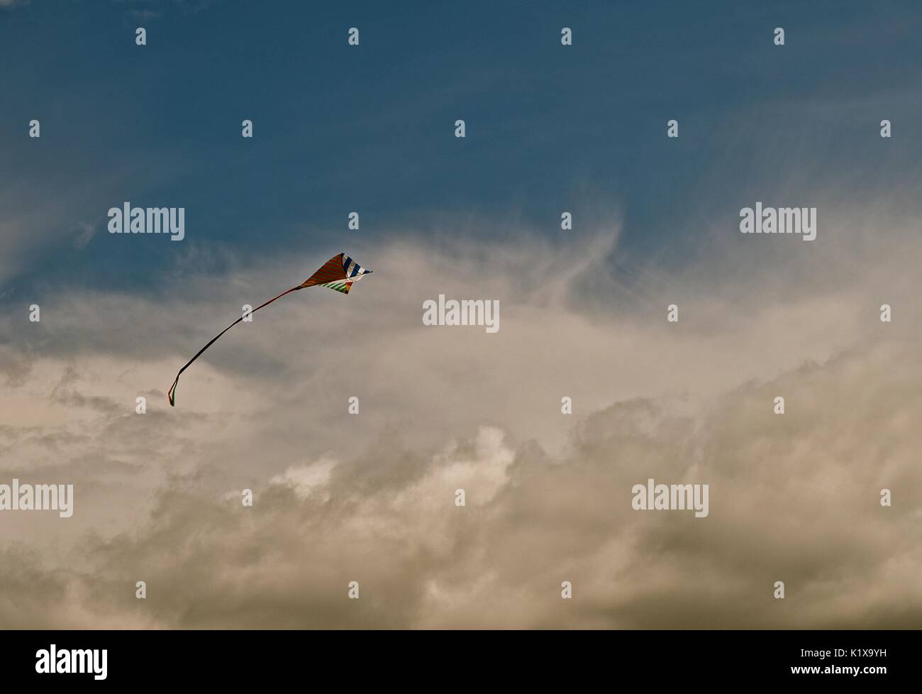 Kite flying freely and afloat in the breeze. A fun and relaxing activity for summer fun. Stock Photo