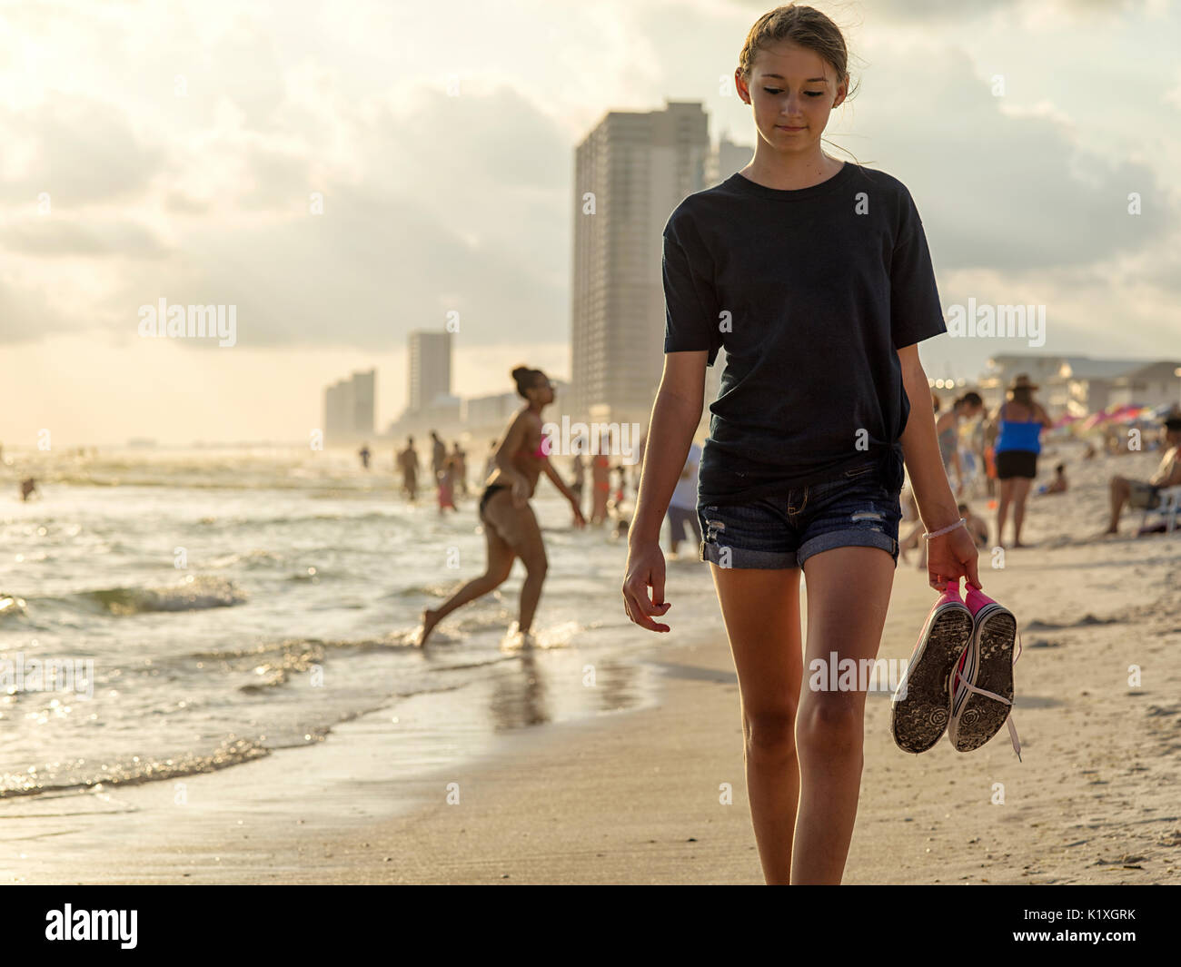 A young girl walks on the beach at sunset. Panama City Beach, Florida. Stock Photo