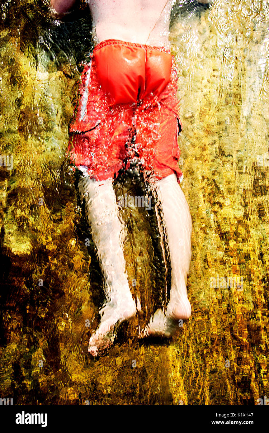 Legs of a young man coming down a dam overflow water slide Stock Photo ...