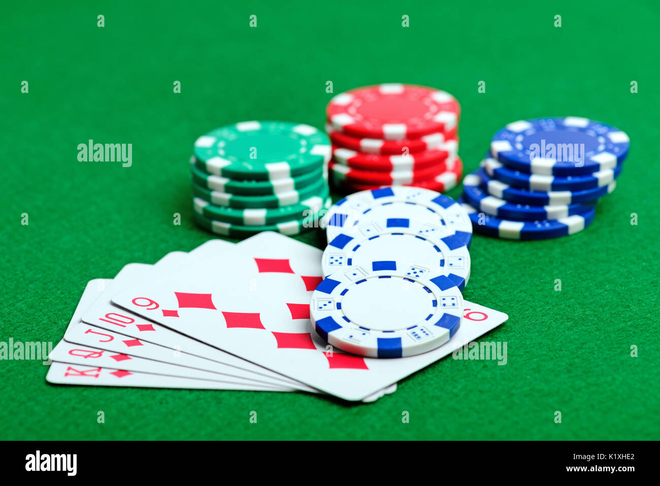 Casino green table with chips and royal flush of playing cards. Poker game concept Stock Photo