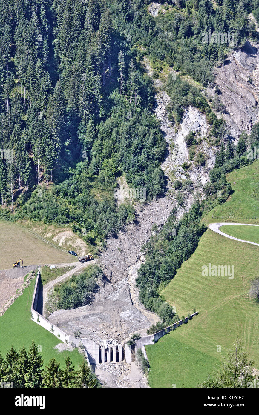 Aerial view of mountain stream in the Austrian Alps blocked after a massive mudflow with excavator and truck working to clean up the site Stock Photo