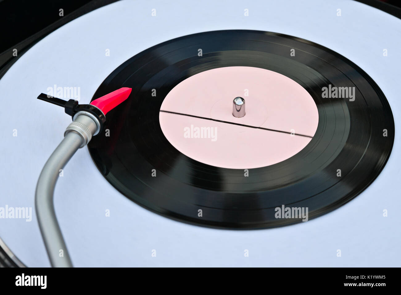 Closeup view of a vinyl disk turntable and tonearm in action. Retro