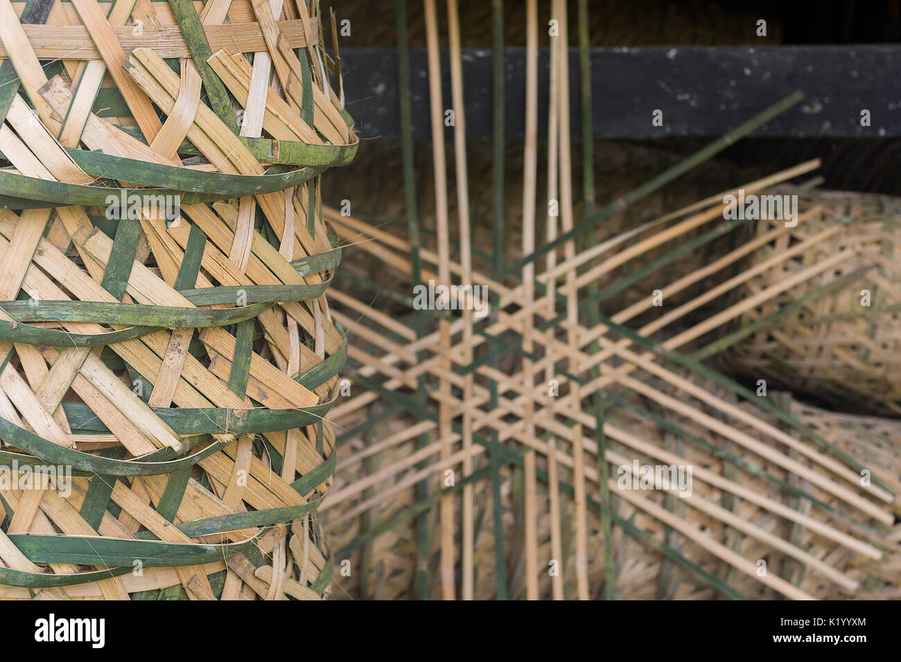 Close up of a stack of Indonesian traditional hand made hand woven bamboo baskets with part made one in the back ground. Stock Photo