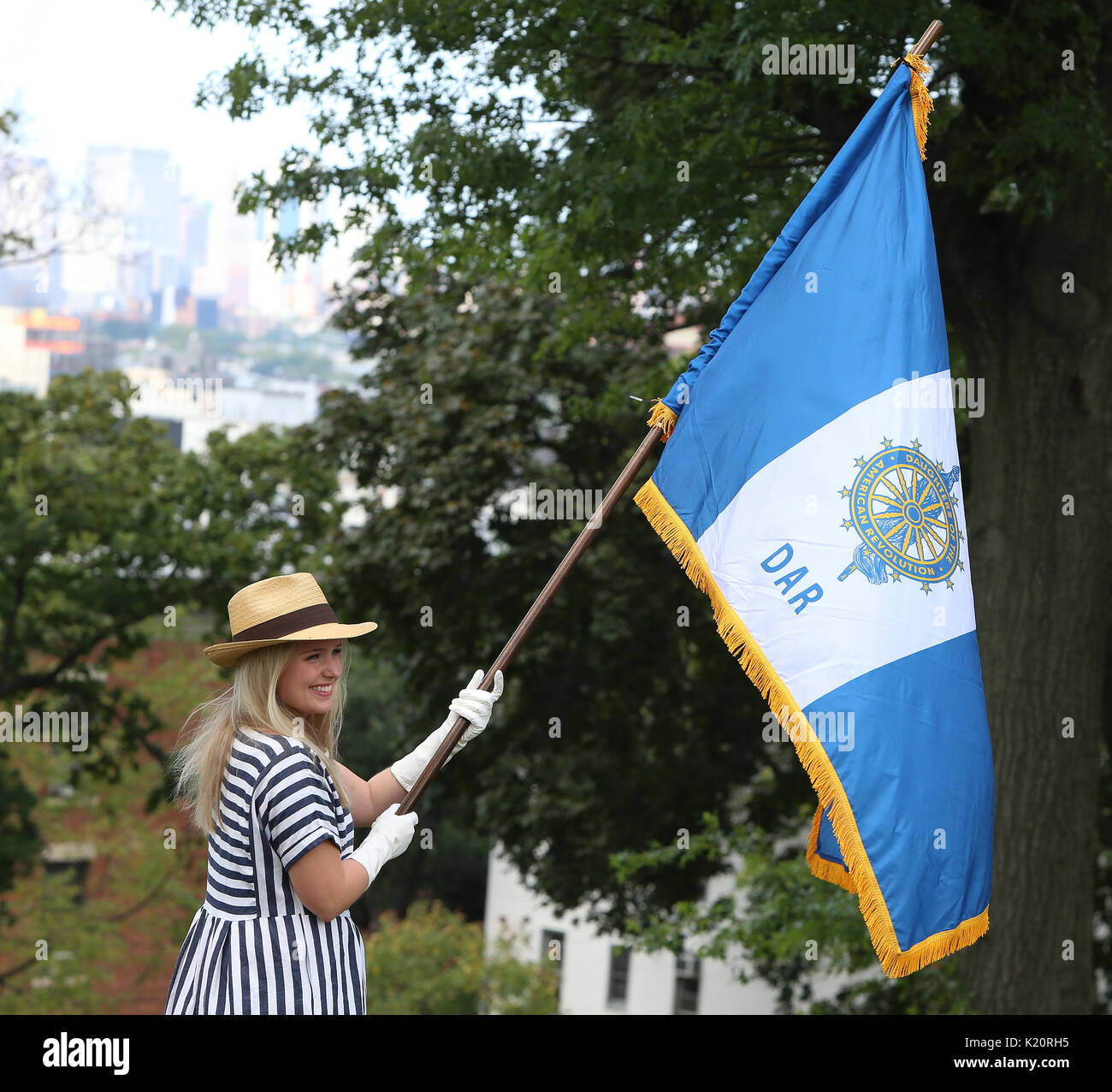 Brooklyn, United States. 27th Aug, 2017. DAR member with Flag. Green-Wood Cemetery in Brooklyn staged its annual Battle of Brooklyn recreation, complete with cannon & musket fire, with re-enactors wearing British & colonial period uniforms performing on the cemetery lawn. After the battle, troops led the way to Battle Hill where a brief ceremony took place, with wreaths put into place honoring the 400 Maryland infantry who endured some 70% casualties attacking British positions on the hill top. Credit: Andy Katz/Pacific Press/Alamy Live News Stock Photo
