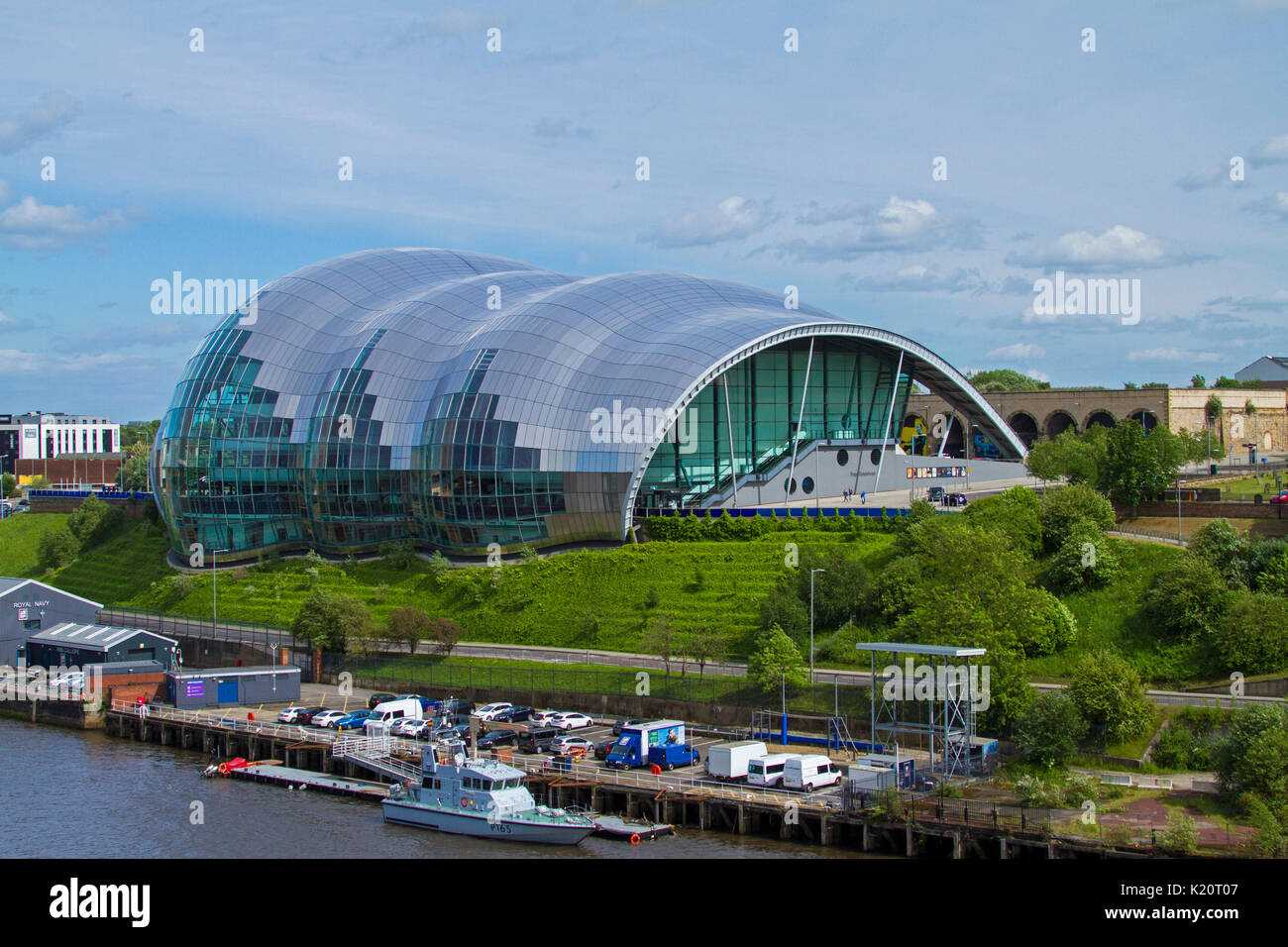 Huge and imposing Gateshead Sage, modern glass building, entertainment venue, beside river and under blue sky at Newcastle-upon-Tyne, England Stock Photo