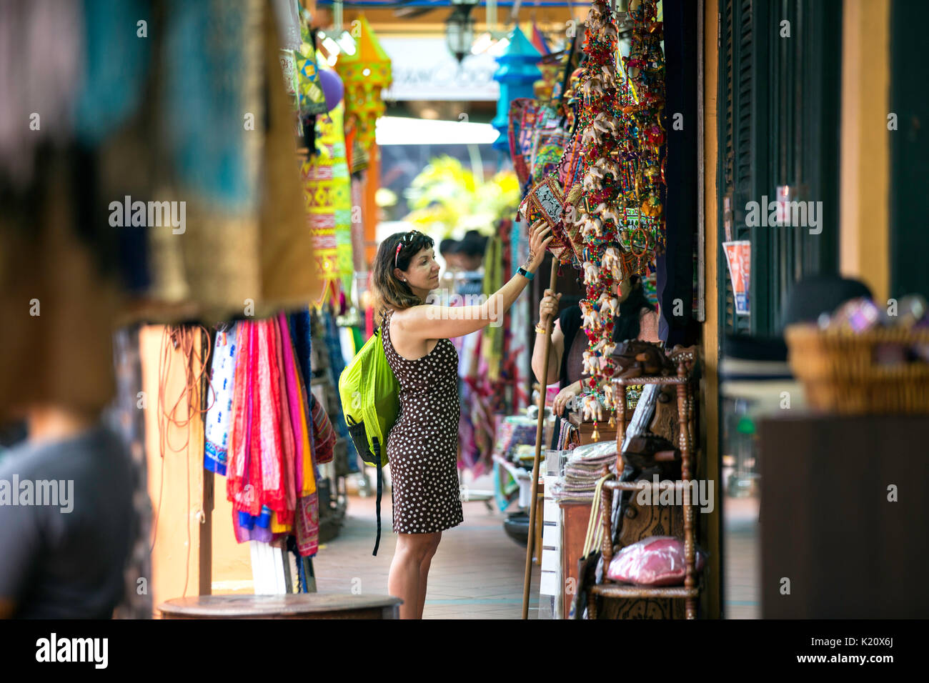 foreign lady tourist shopping for colourful indian curios in a indian handicraft souvenir shop in little india,little india arcade,singapore,asia Stock Photo