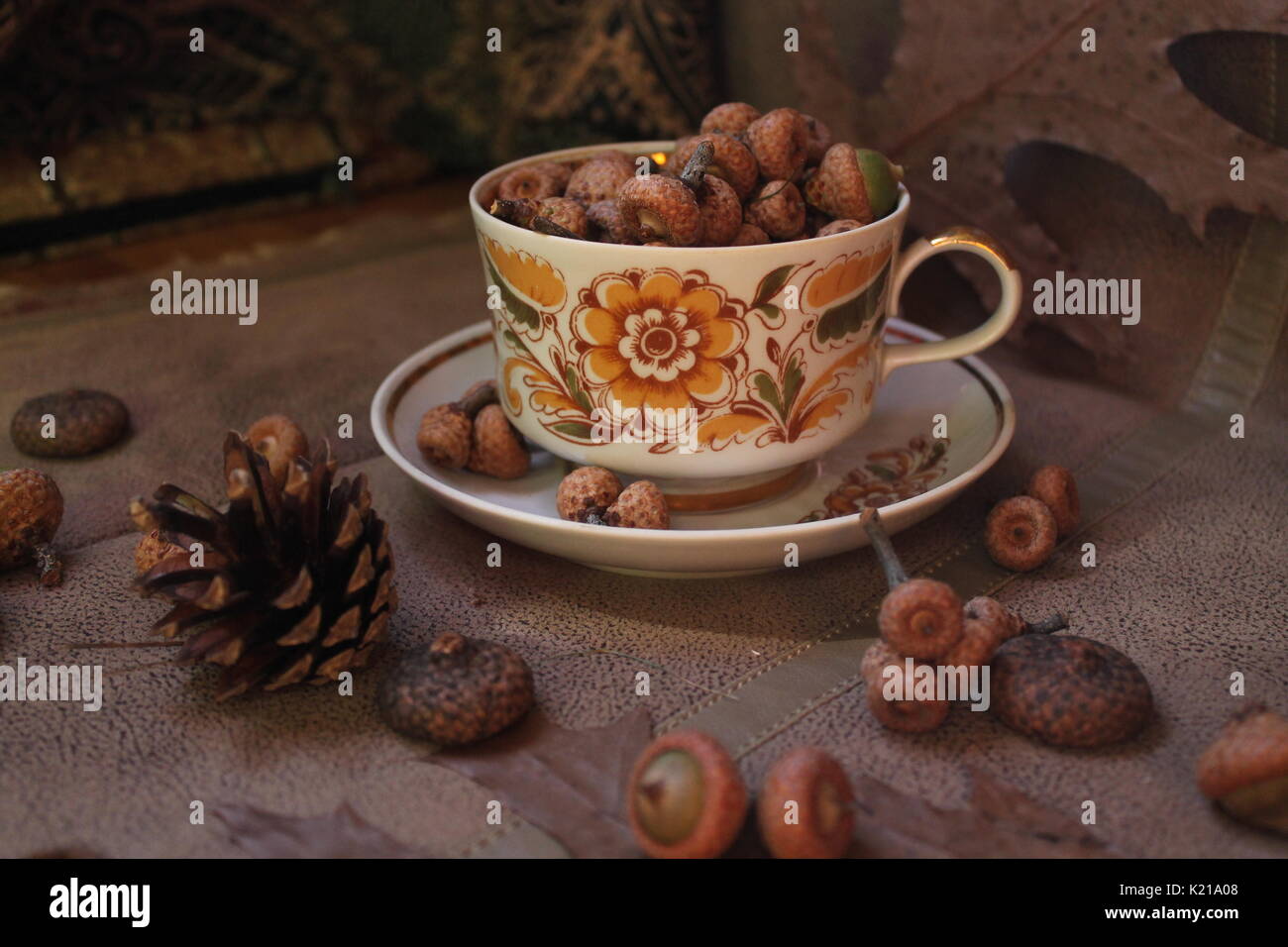 retro style tea set full oak acorns decorated with dry brown leaves and flowers, fir cones and juicy pink apples Stock Photo