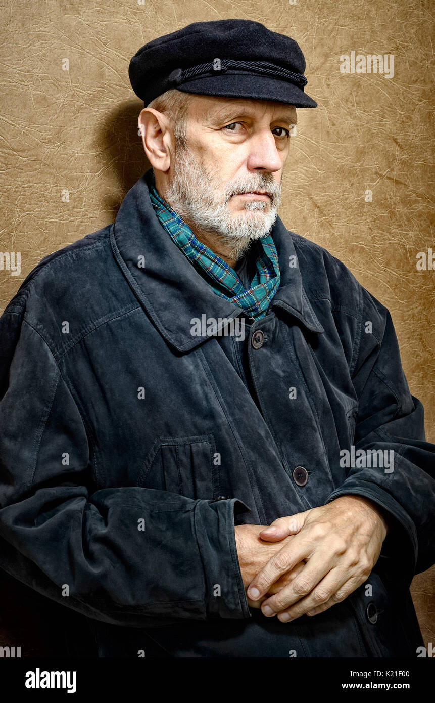 Portrait of a mature man with a white beard and a cap on the head. He could be a sailor, a worker, a docker, or even a gangster or a thug. He has a pe Stock Photo