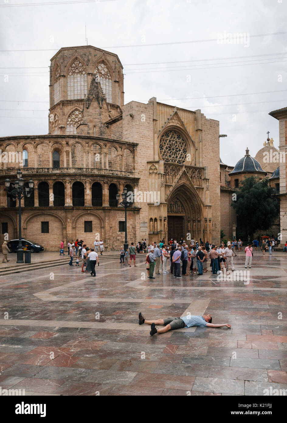 Valencia, Spain - June 3, 2016: Young man lies on square of Saint Mary with local and tourists in Valencia Old Town in the evening, Spain Stock Photo