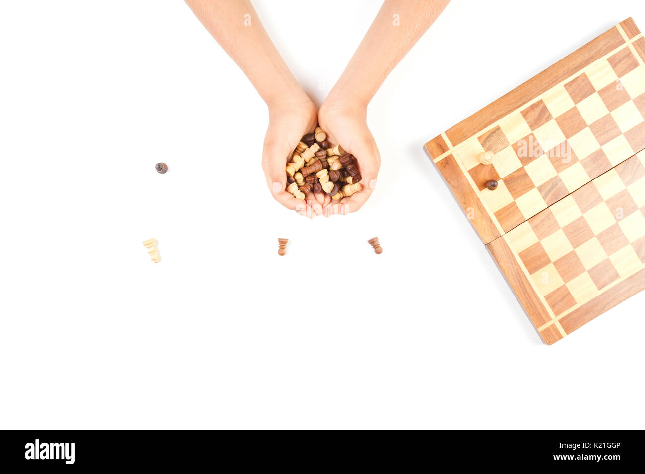 Chess board with chess pieces and a kid hand. Stock Photo