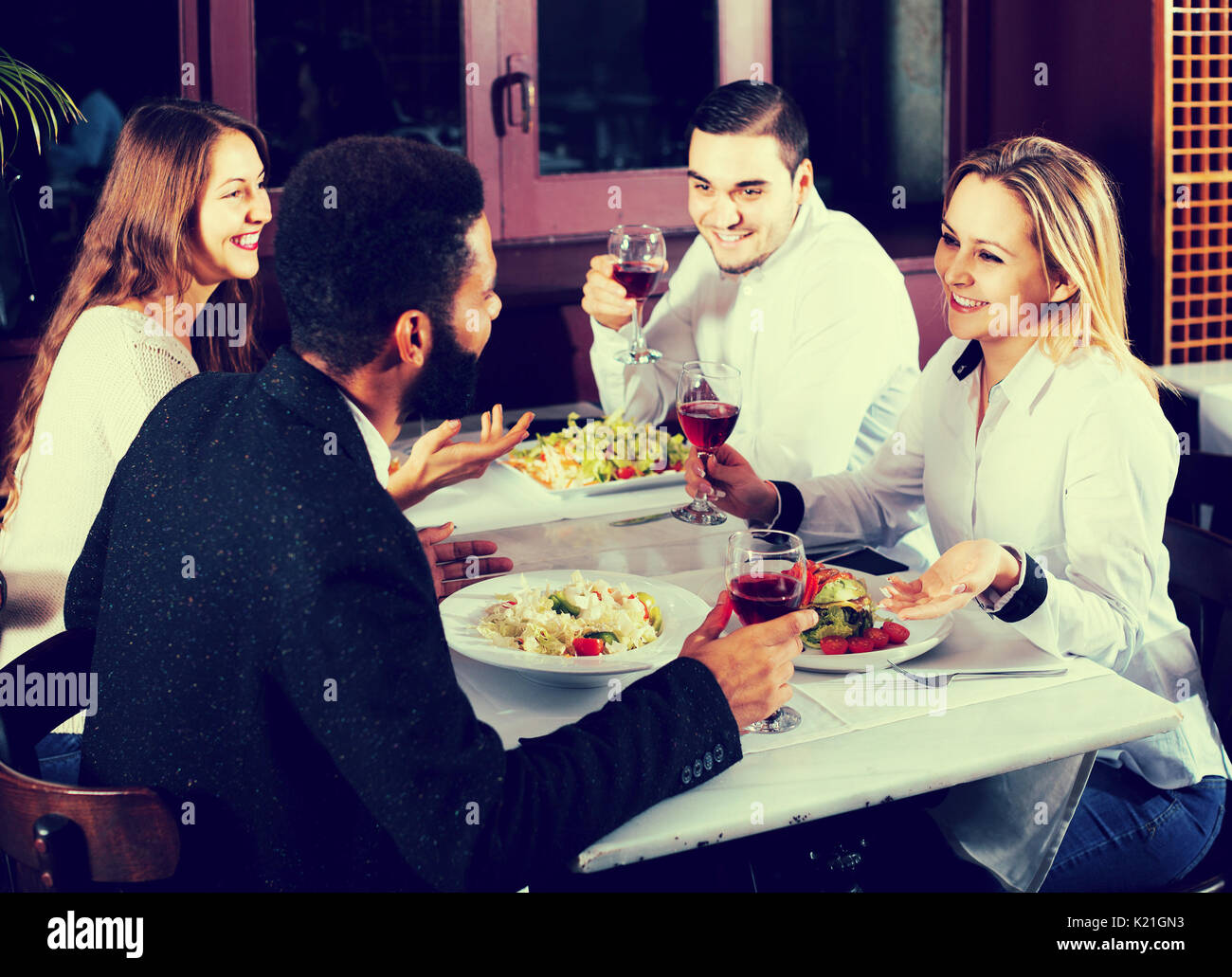 smiling middle class european people enjoying food in cafe and talking ...