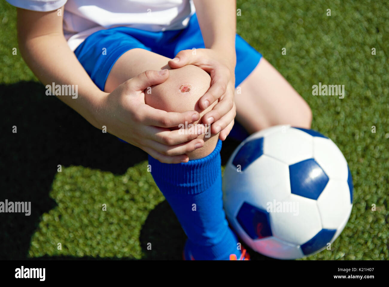 Injury of the knee in the boy football soccer player Stock Photo Alamy