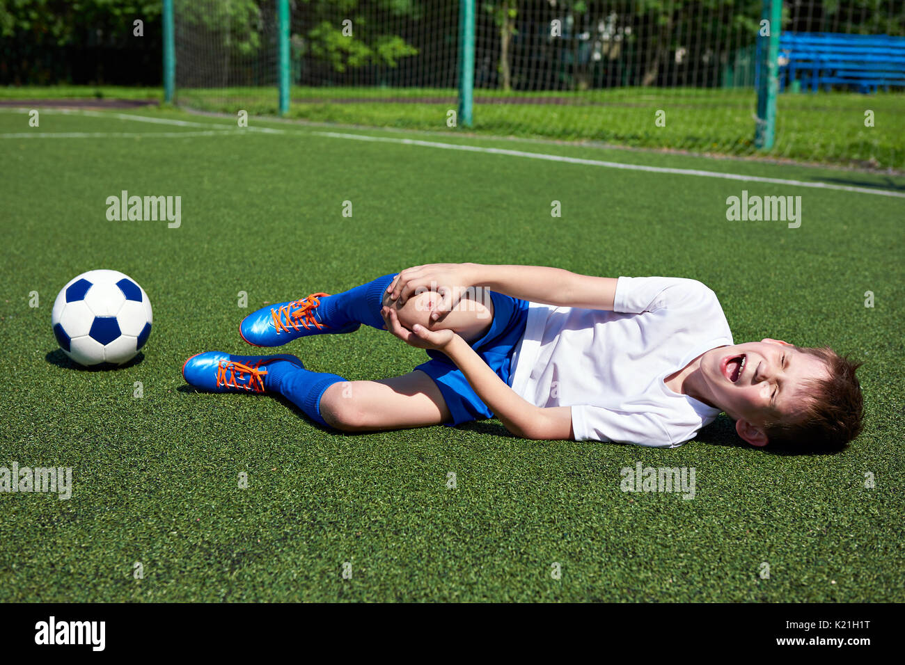 Injury of the knee in the boy football soccer player Stock Photo Alamy