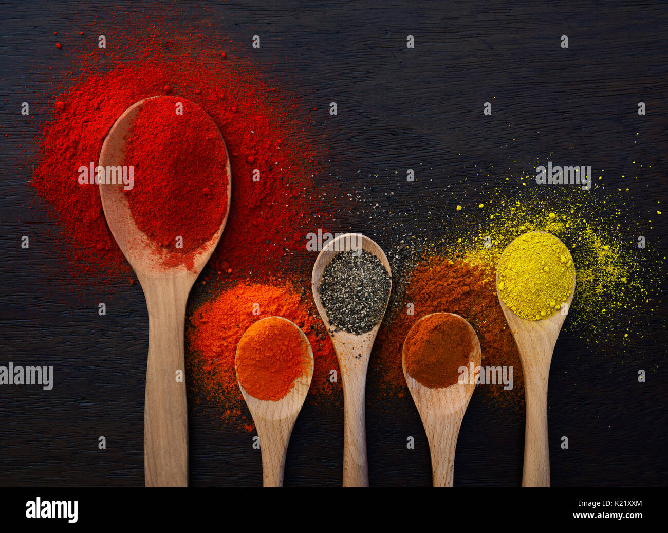 Wooden spoon filled with powders and ground spices Stock Photo