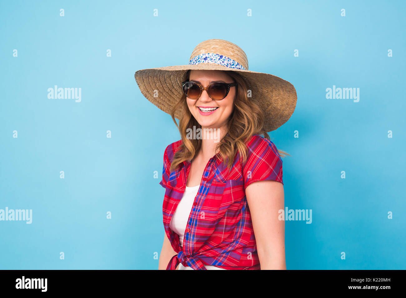 Beautiful young woman wears in summer dress and straw hat is laughing ...