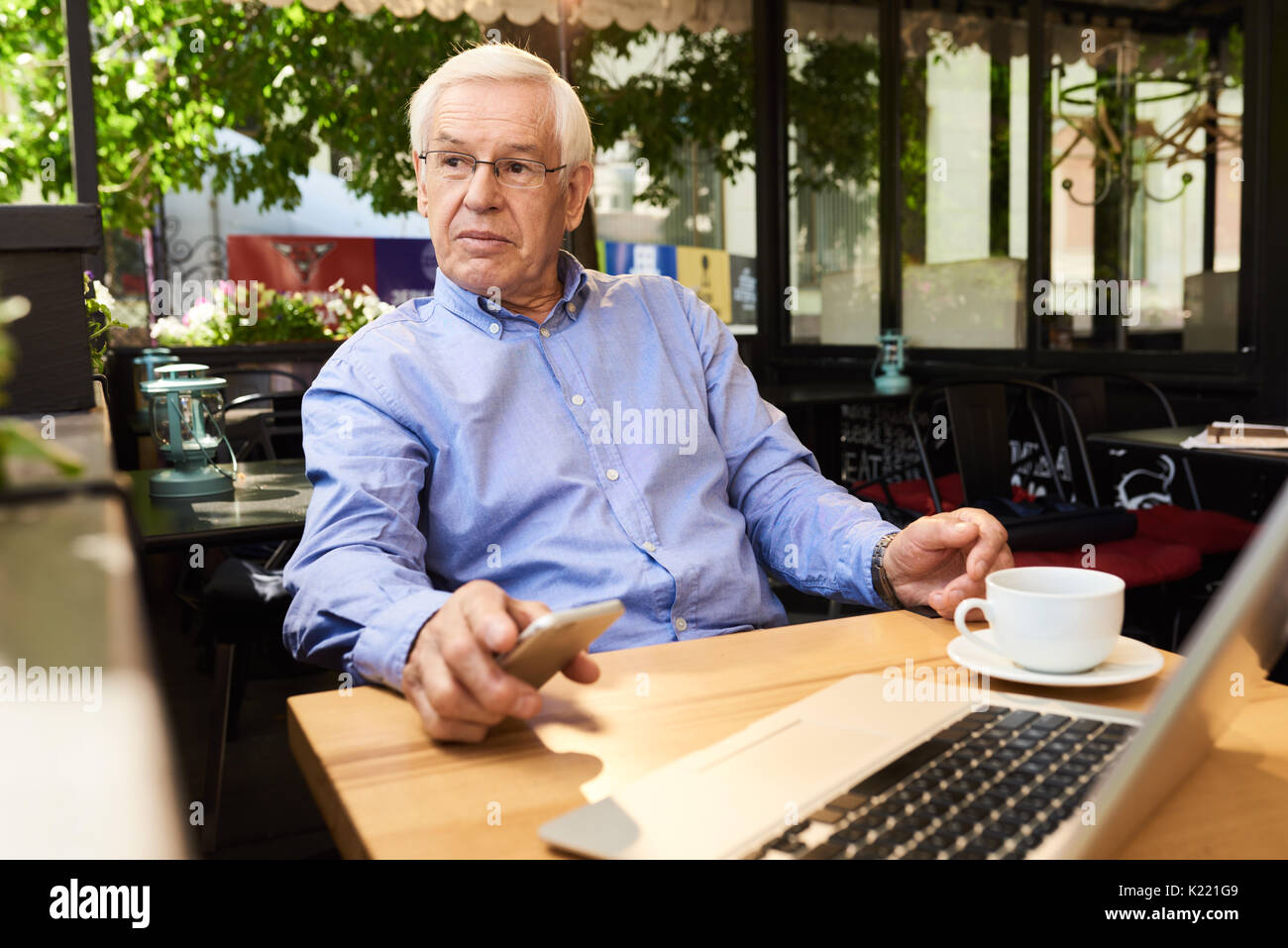 Modern Senior Man Taking Break  in Outdoor Cafe Stock Photo