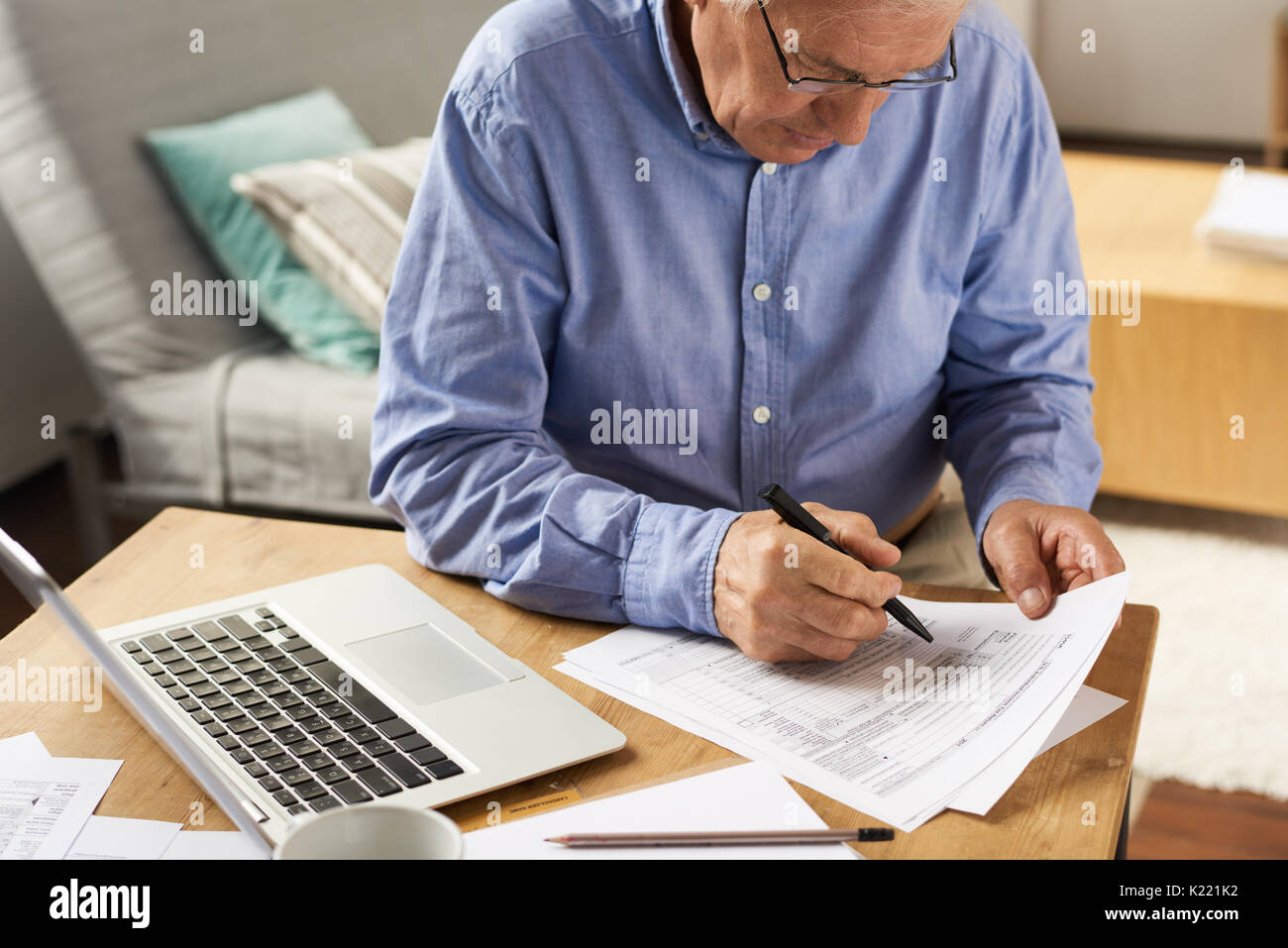 Senior Man Filling Application Form at Home Stock Photo