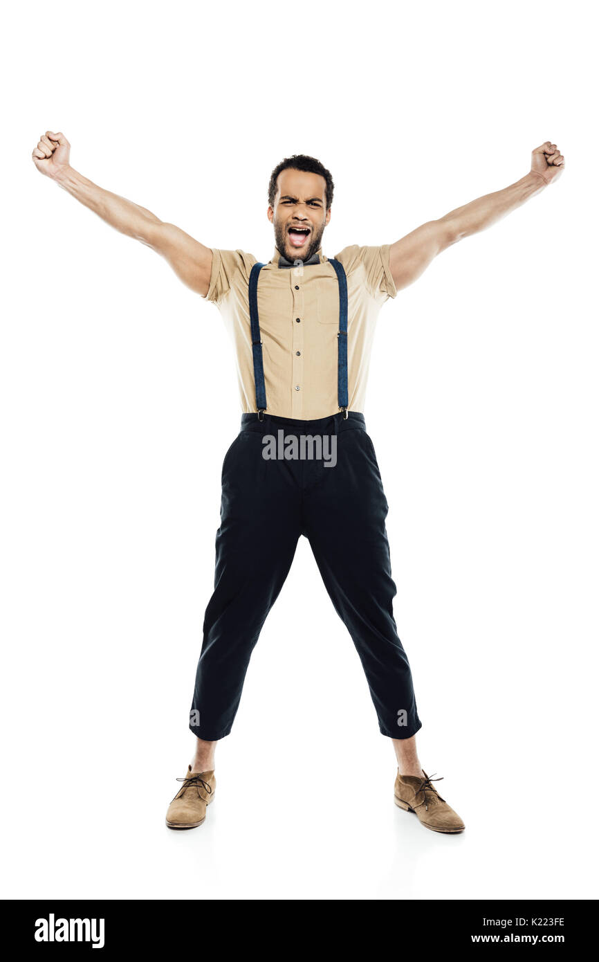 cheerful african american man wearing in suspenders and bow tie yelling and celebrating success isolated on white Stock Photo