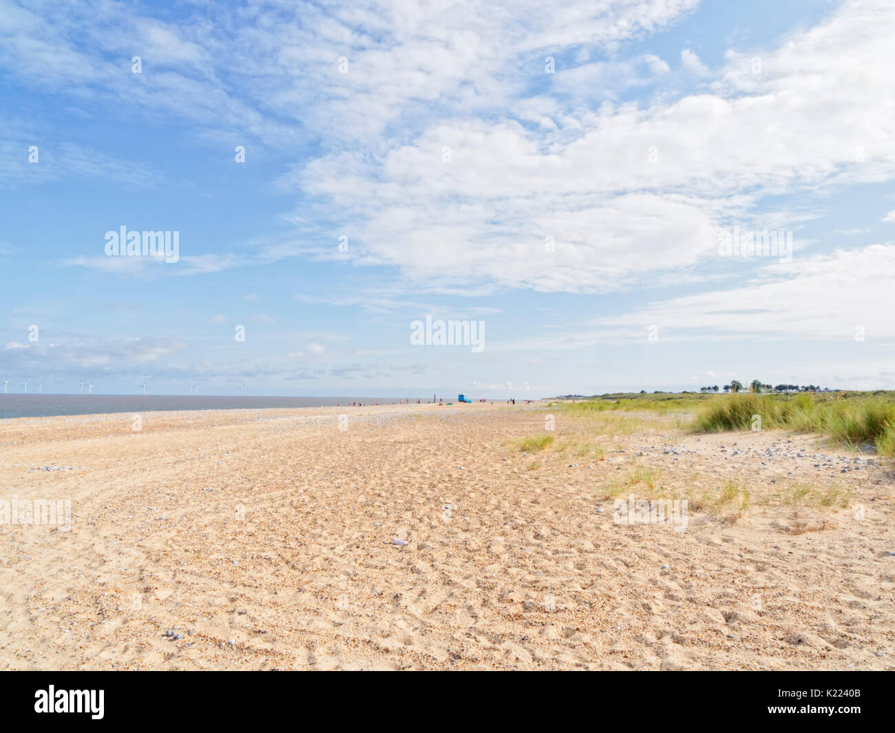 On a wide empty beach in Caister-on-Sea with a small group of people in ...