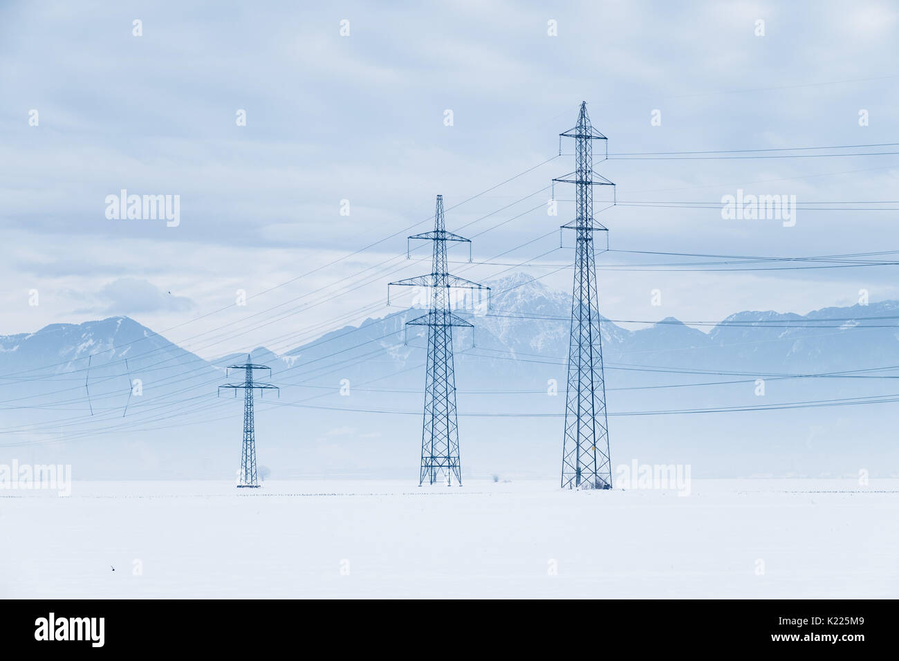 Electric pylons in the snow field Stock Photo - Alamy
