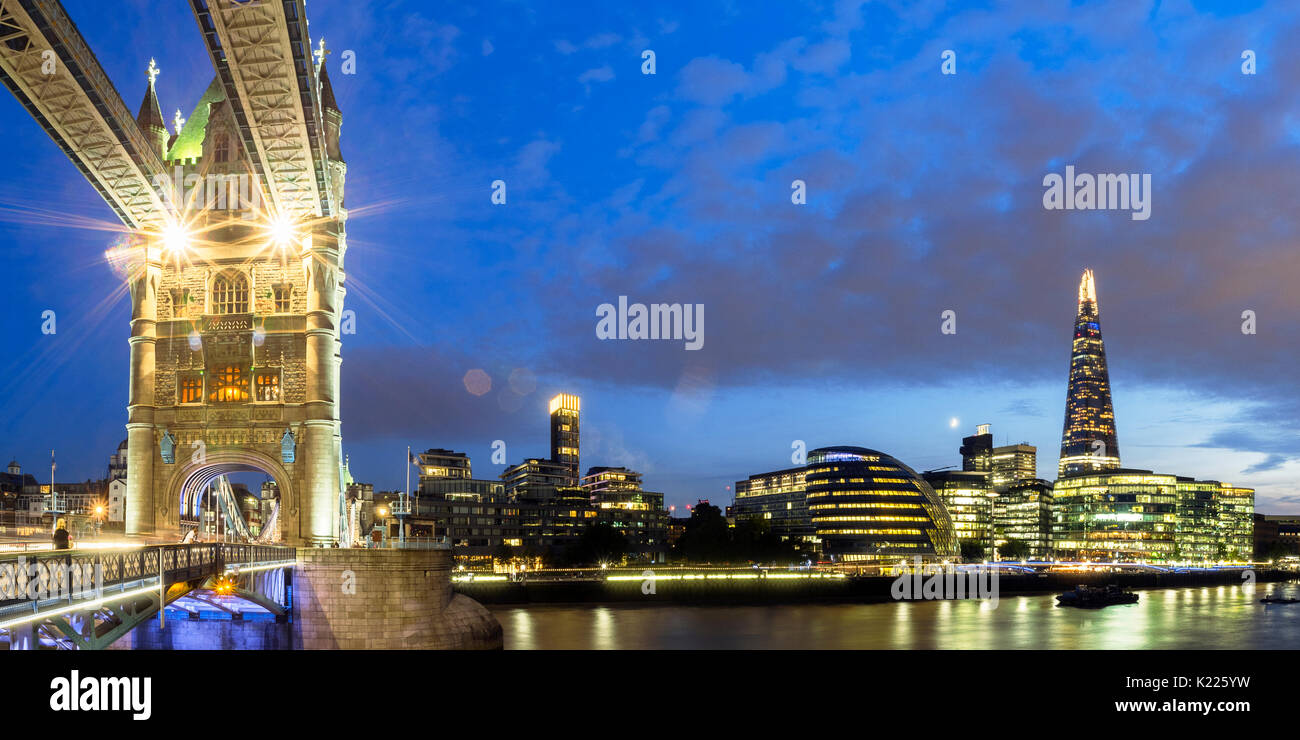 UK, London, Panoramic view of Tower Bridge and the city skyline across South of River Thames, lit up at night Stock Photo
