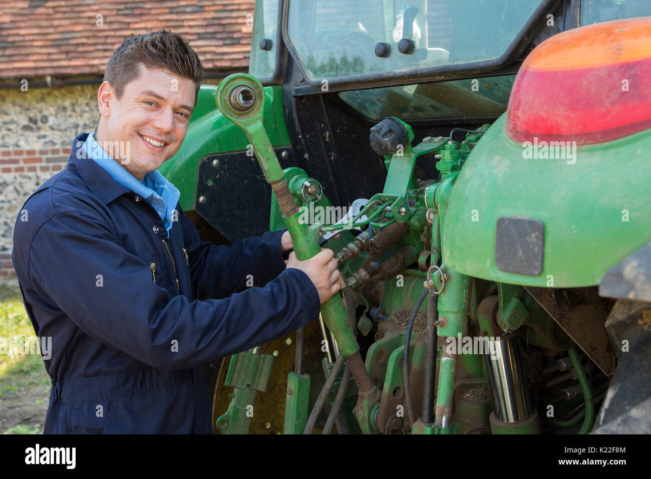 Portrait Of Mechanic Repairing Tractor On Farm Stock Photo Alamy
