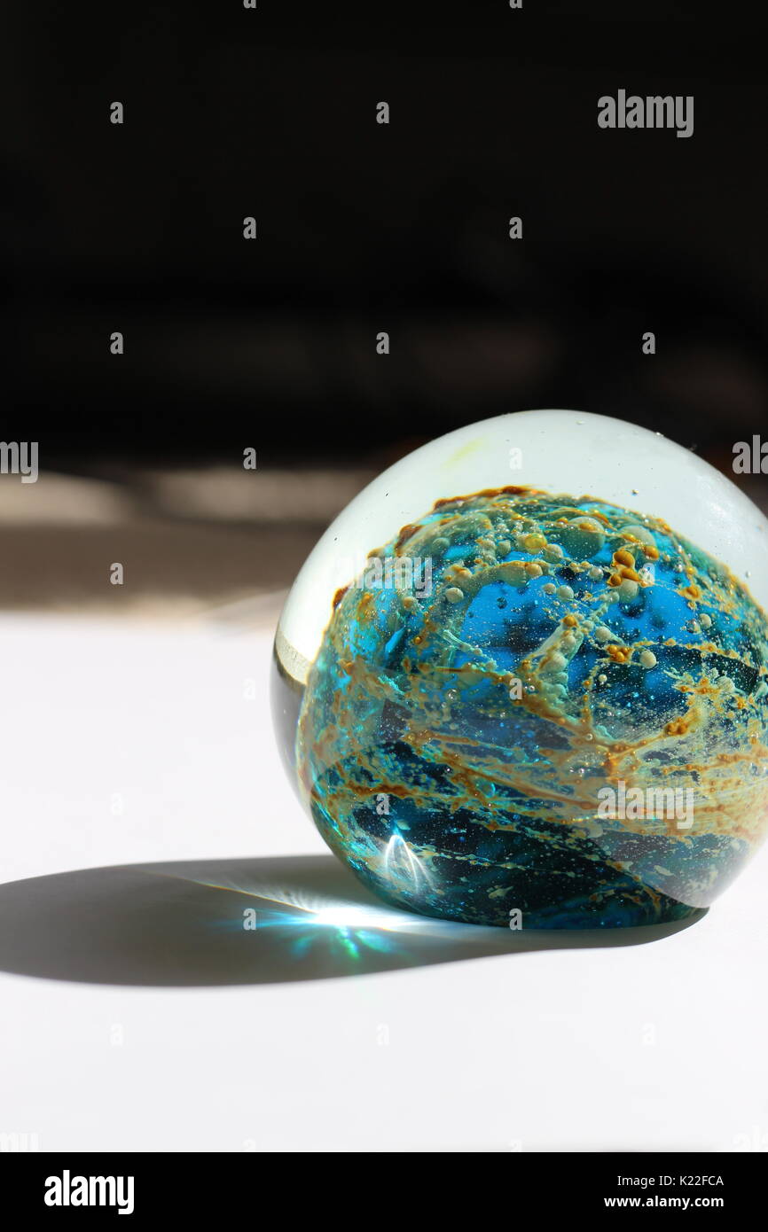 A blown glass orb from Malta gives a glimpse into the universe with beautiful space-like patterns and light refractions Stock Photo