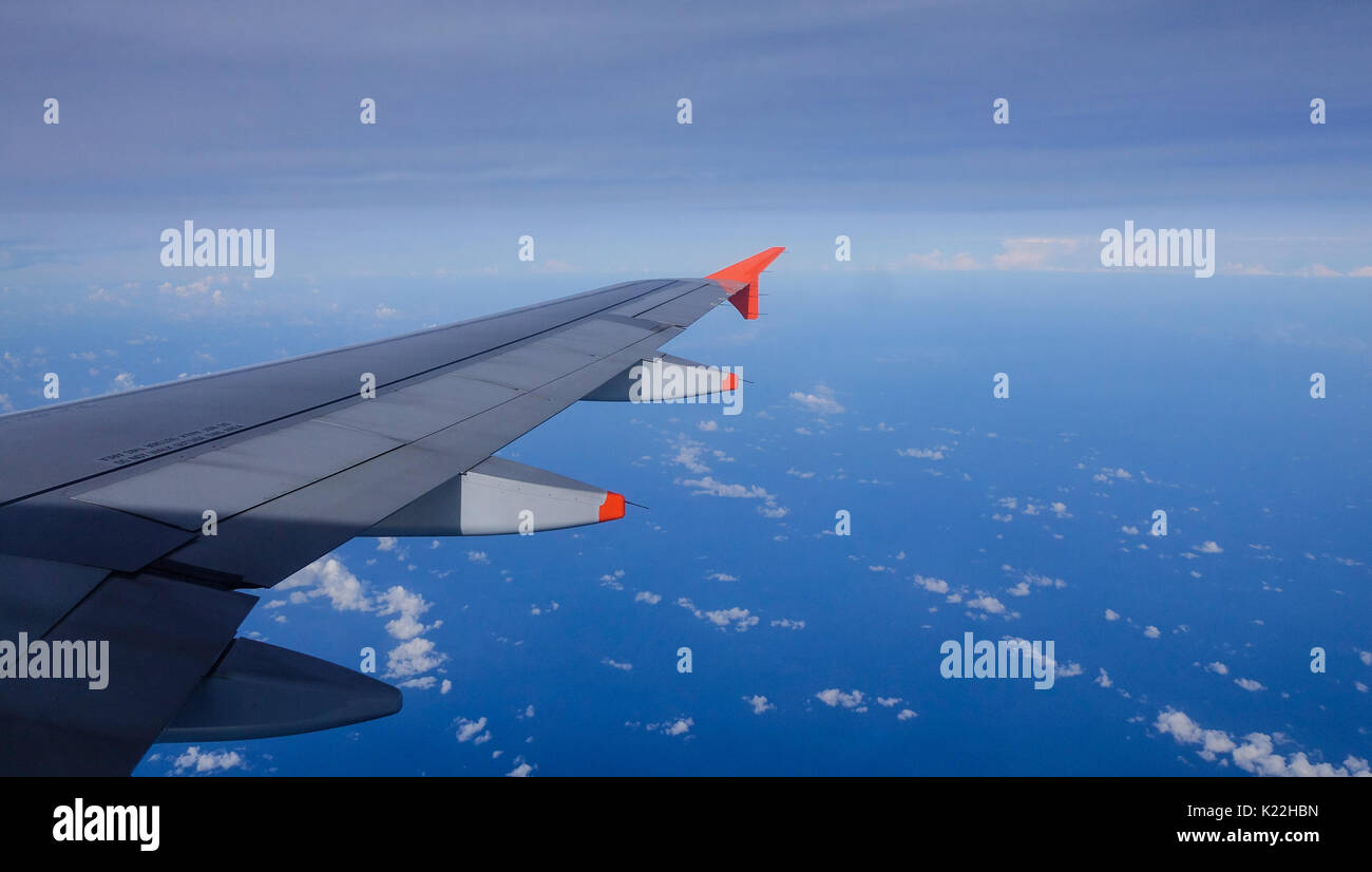 Wing of an airplane flying above the beautiful cloudy sky Stock Photo ...