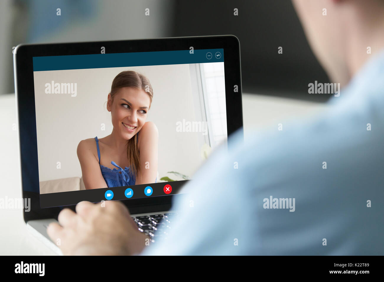 Man talking to shy woman by video call, virtual dating Stock Photo
